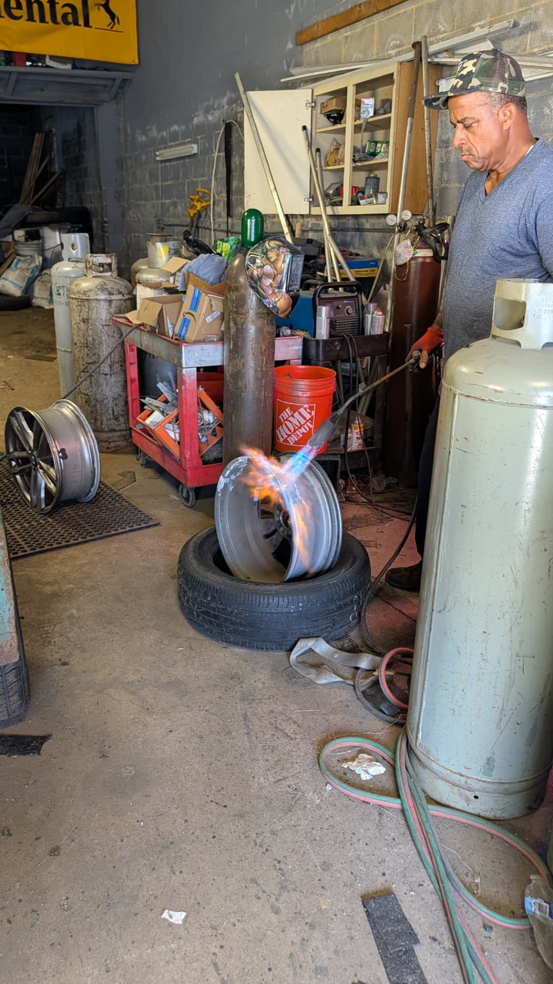 CDM Tires technician heating an aluminum rim with a torch before welding