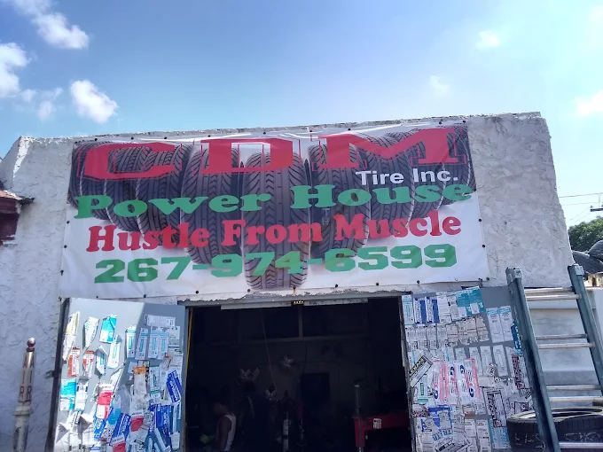 CDM Tires shop front on Lancaster Ave with the open garage bay